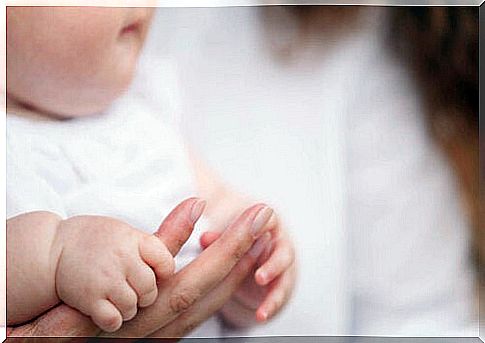 baby holding mother's hand