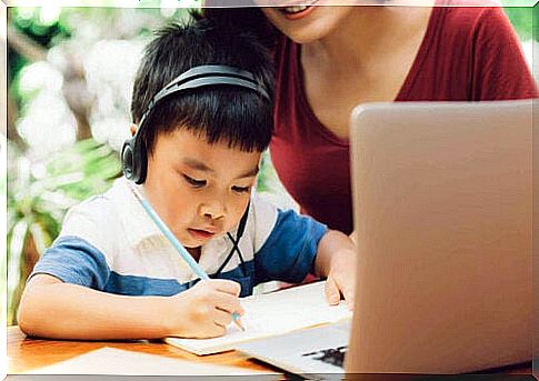 little boy studying by computer