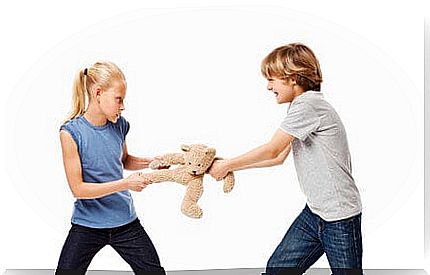 a boy and girl fighting for a teddy bear