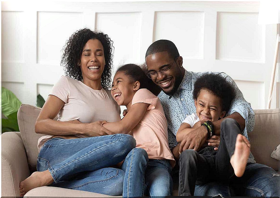 A family laughing together on the couch