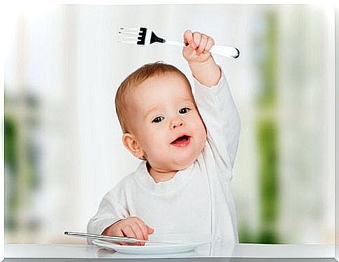 baby holding a fork