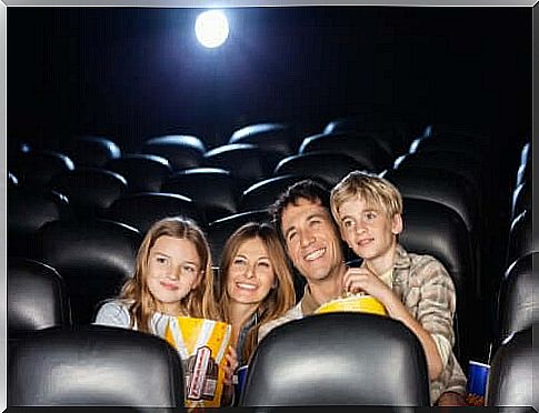 family with popcorn in cinema