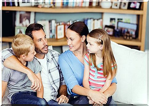 family of four talking on sofa