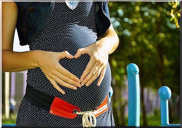 future mother forming a heart on her stomach with her hands