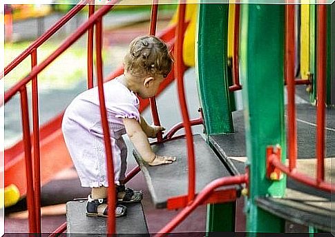 Baby crawls up stairs on the playground 