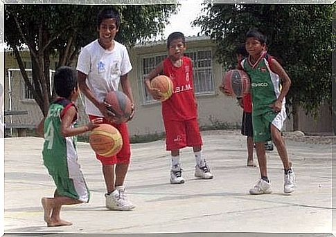 barefoot children play basketball