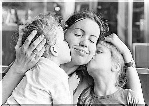 Mother is kissed by her children