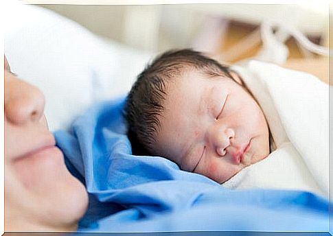 newborn baby lying on mother