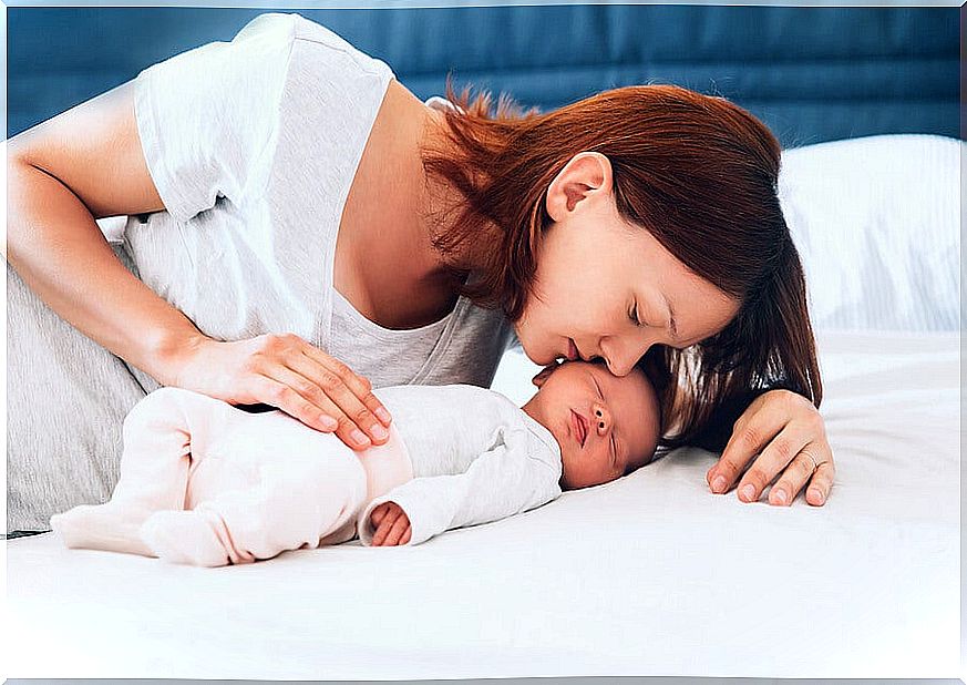 mother kissing sleeping baby