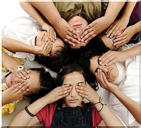 Children lying in a circle and keeping their eyes open.