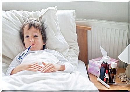 child in bed with thermometer in mouth