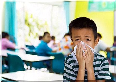 child in school brushing nose