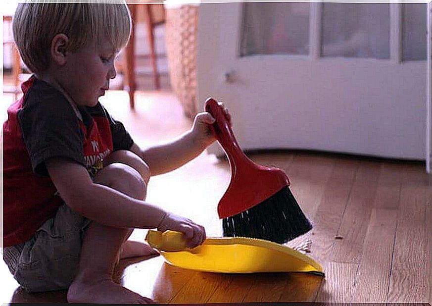 Duty schedule for children: Little boy sweeps up on the floor.