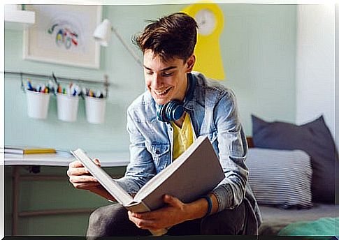 young boy reading in a big book