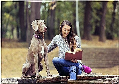 woman reading outside for a dog