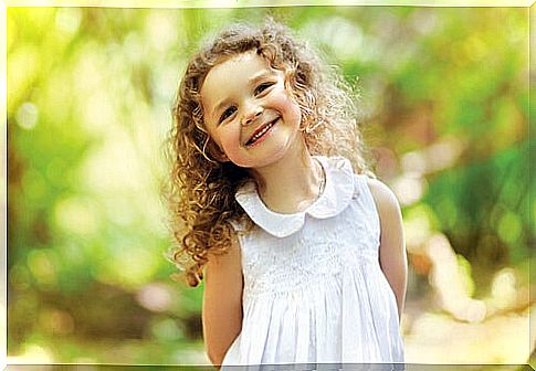 little happy girl with curls in white dress