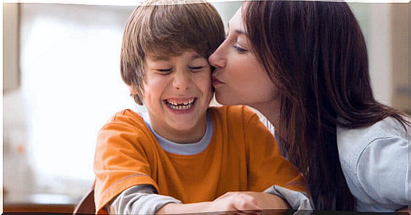 mother kissing smiling boy on cheek