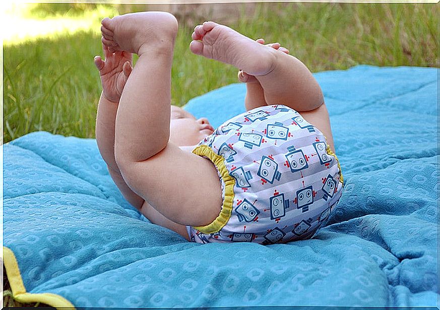 little baby on a blanket on a lawn