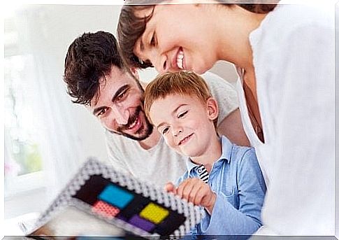 Mom, dad and son looking at pictures together