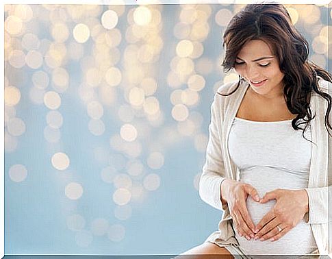 woman forming a heart on her pregnant belly