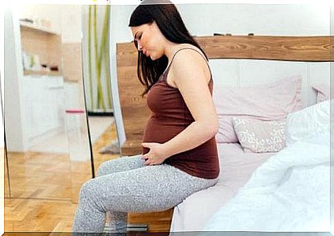 pregnant woman on the edge of bed