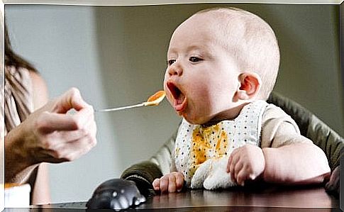 baby being fed with food on a spoon