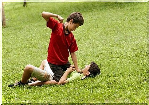 2 children beat each other on a lawn