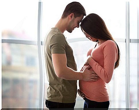 pregnant woman and man are standing close together