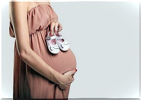 Pregnant woman with baby shoes