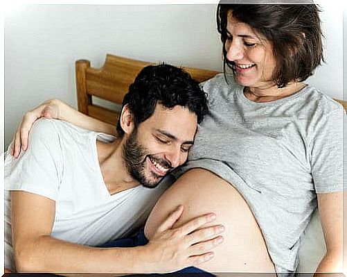 father touching pregnant woman's belly