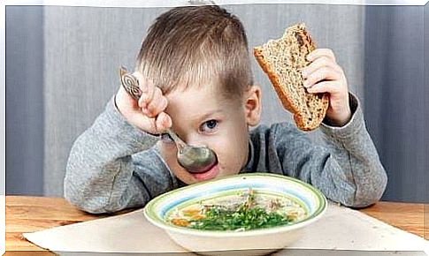 Children eat soup with bread