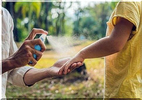 Mother sprays child with insect repellent