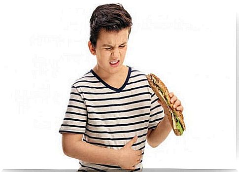 boy with sandwich who has a stomach ache