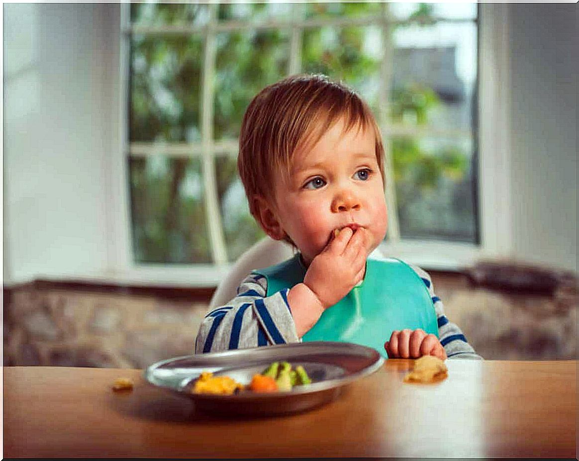 A baby eats with his hands