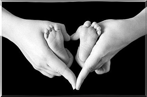 small baby feet and mother's hands