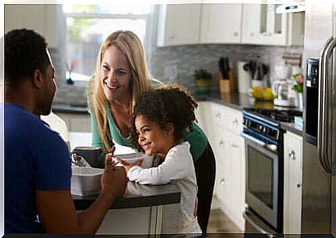 parents talking to child at breakfast in kitchen